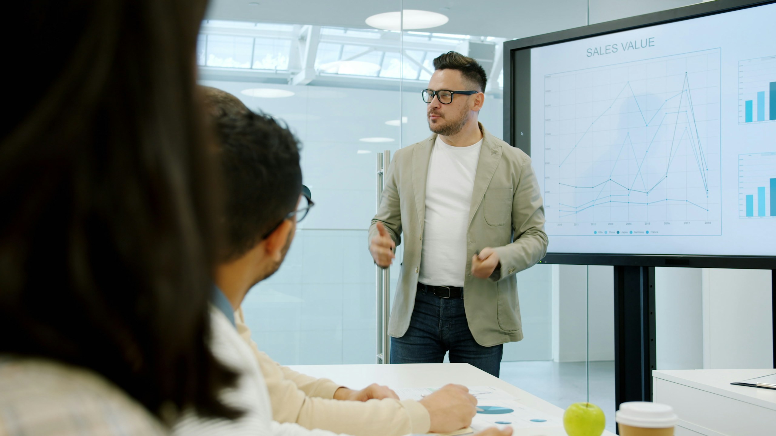 Business trainer is giving lecture on marketing showing info on digital screen in office speaking with group of people. Sales, finance and development concept.