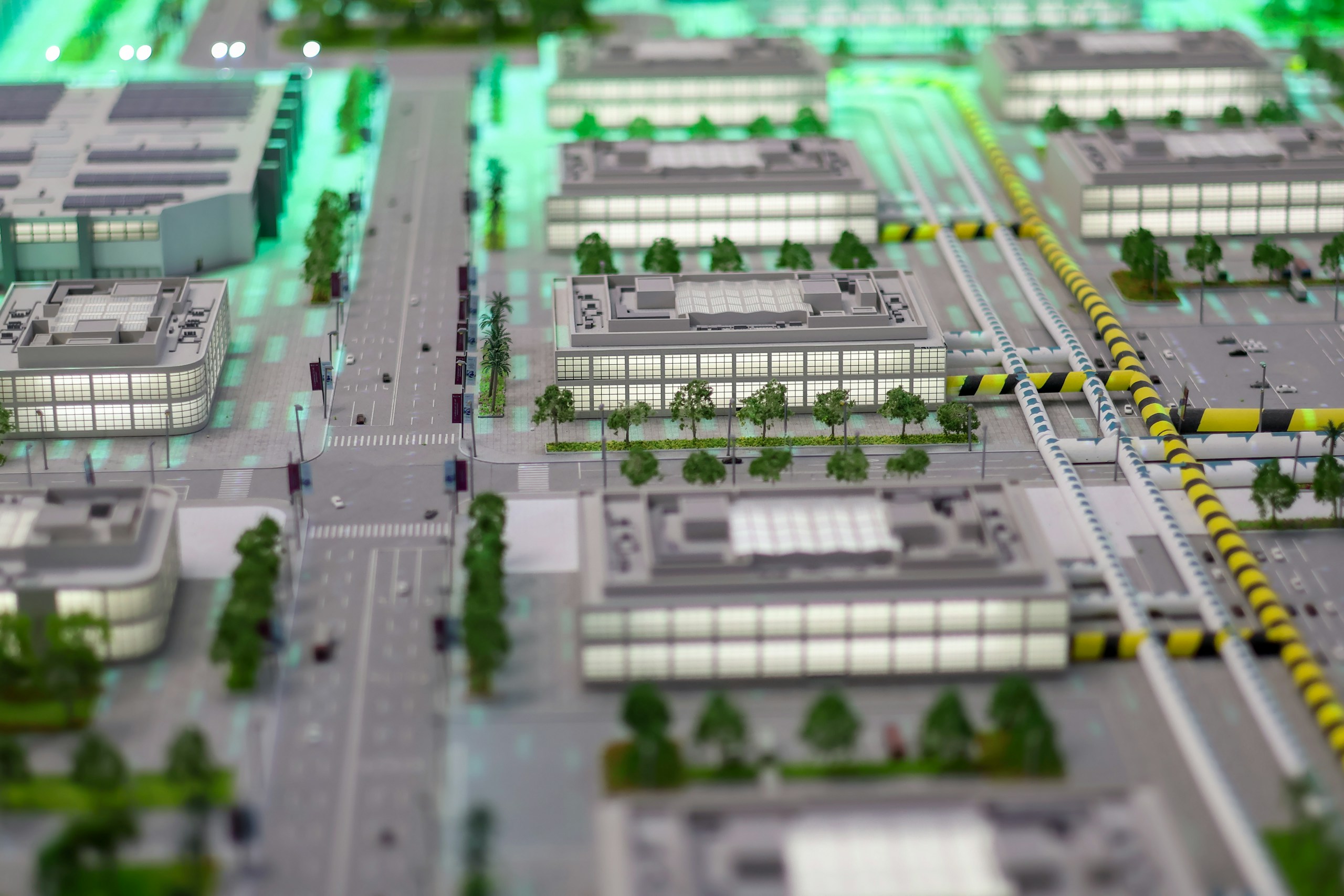 Detailed miniature model of a modern city with illuminated buildings, roads, and advanced infrastructure, illustrating urban planning, innovation, green spaces, and smart city concepts.