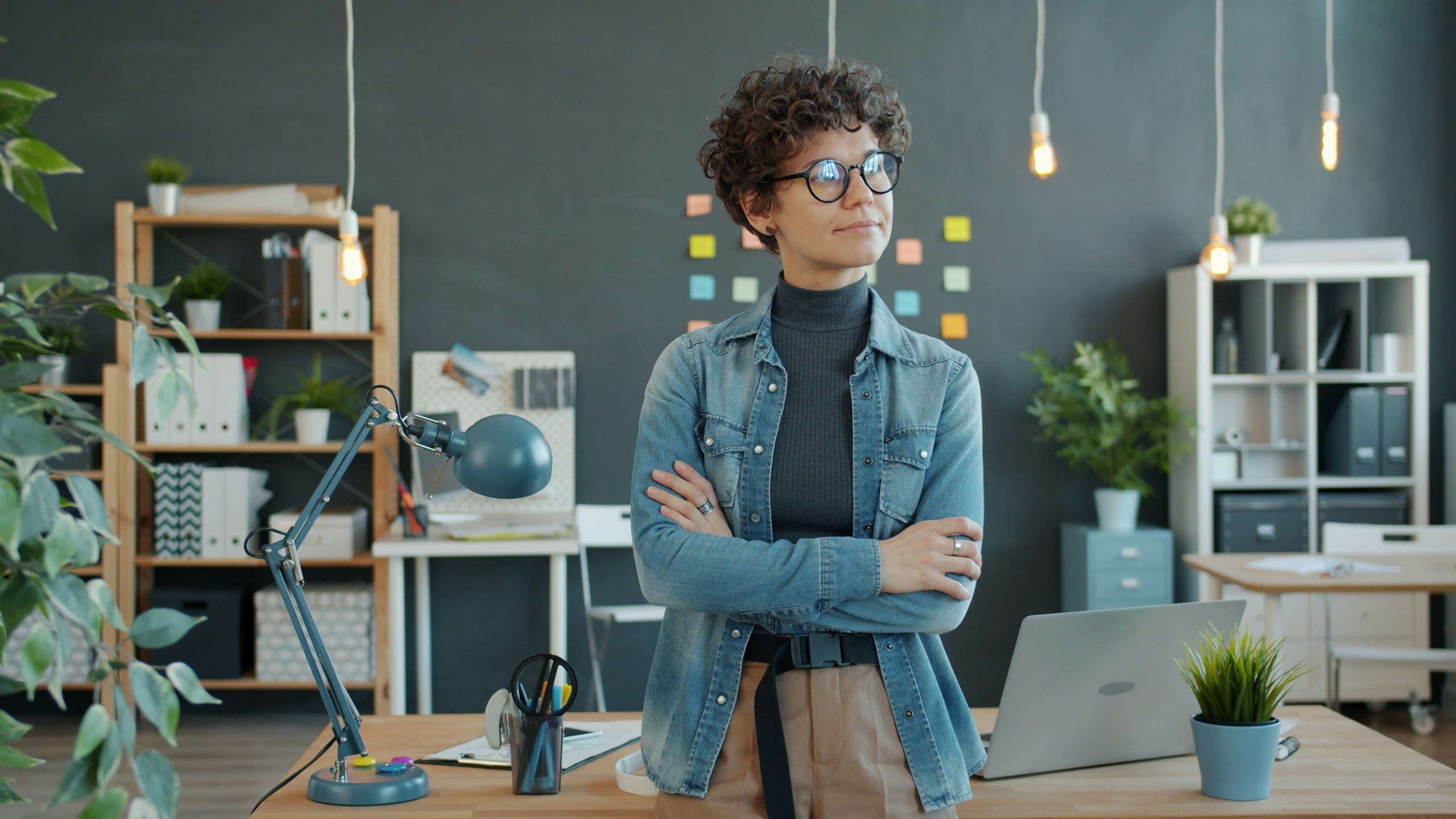 businesswoman standing in office with thinking focused on decisions.